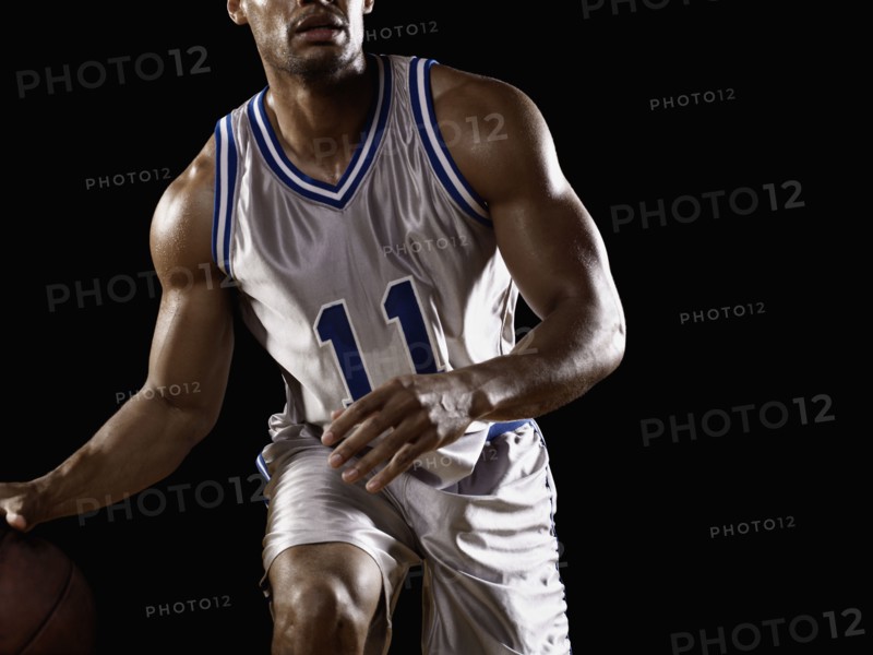 Mixed race basketball player bouncing basketball