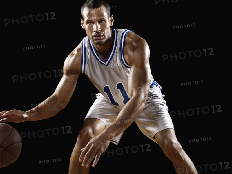 Mixed race basketball player bouncing basketball