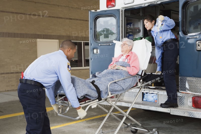 Paramedics putting senior woman into ambulance