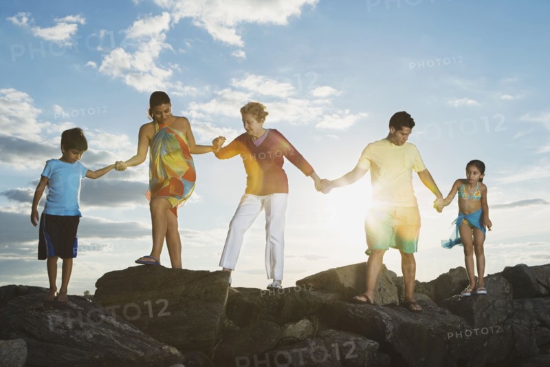 Low angle view of Hispanic family holding hands on rocks