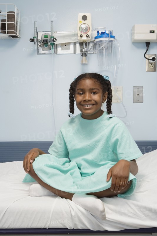 Young African girl sitting in hospital bed smiling