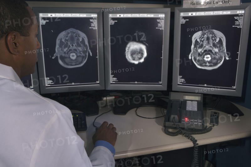 Rear view of African male doctor reviewing at brain scans