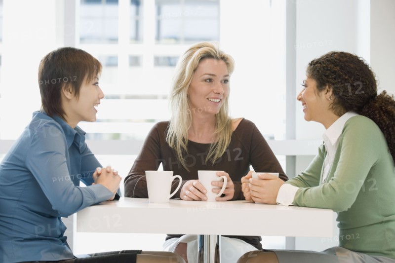 Multi-ethnic women talking at cafe