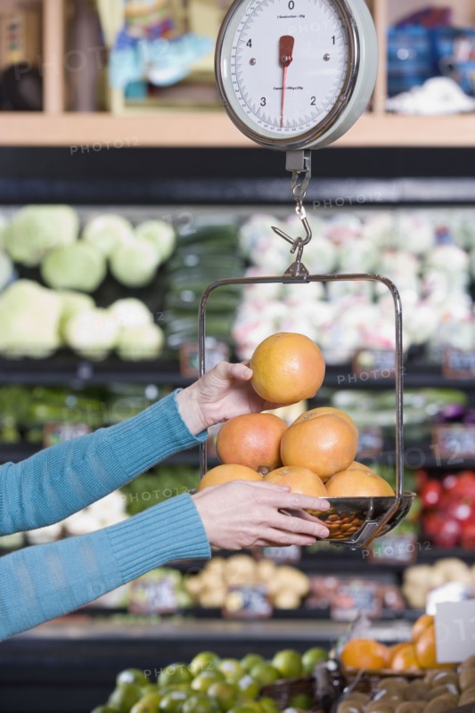 Woman weighing fruit at grocery store