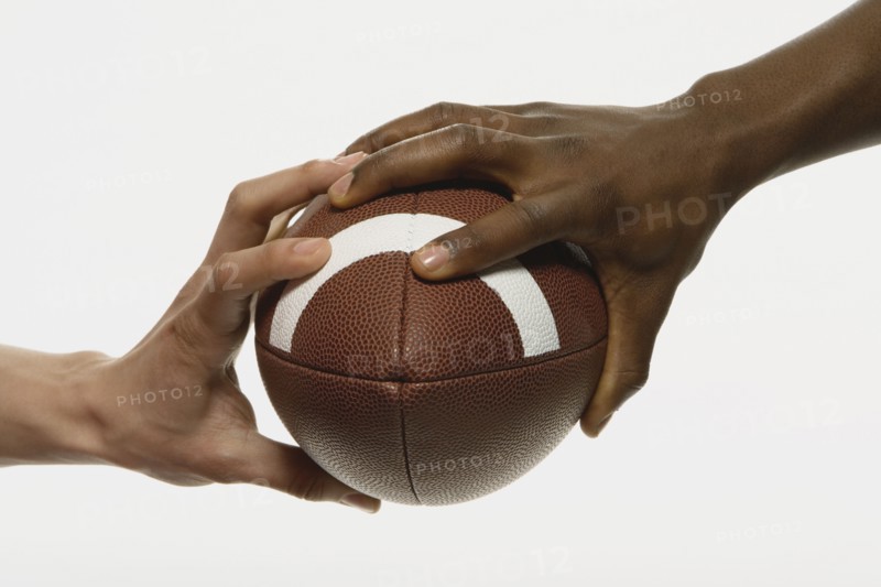 Multi-ethnic men holding football