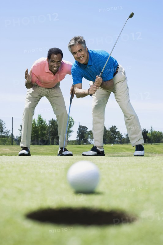 Multi-ethnic men looking at golf ball