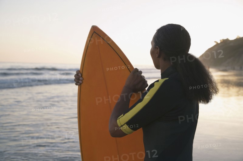 Mixed Race woman holding surfboard