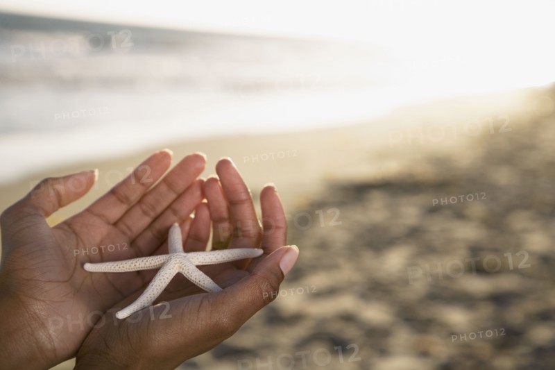 African woman holding starfish