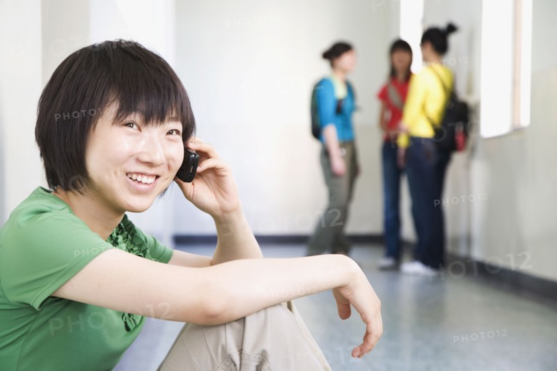 Chinese woman talking on cell phone in corridor