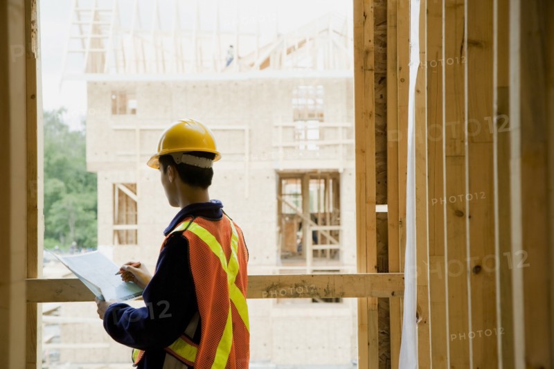 Chinese construction worker writing on clipboard