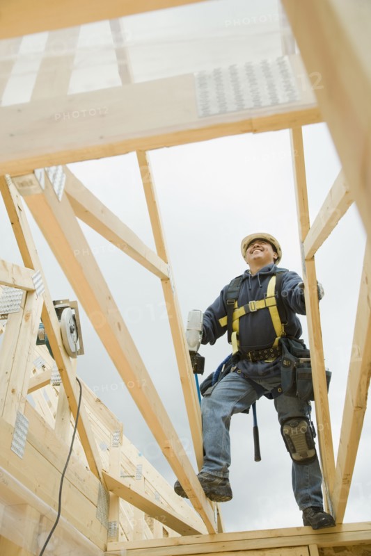 Hispanic construction worker building house