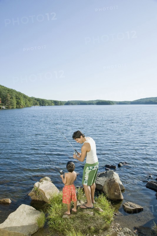 Mixed race father and son fishing in lake