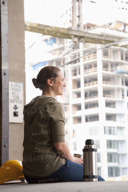 Mixed race woman taking a break on warehouse loading dock
