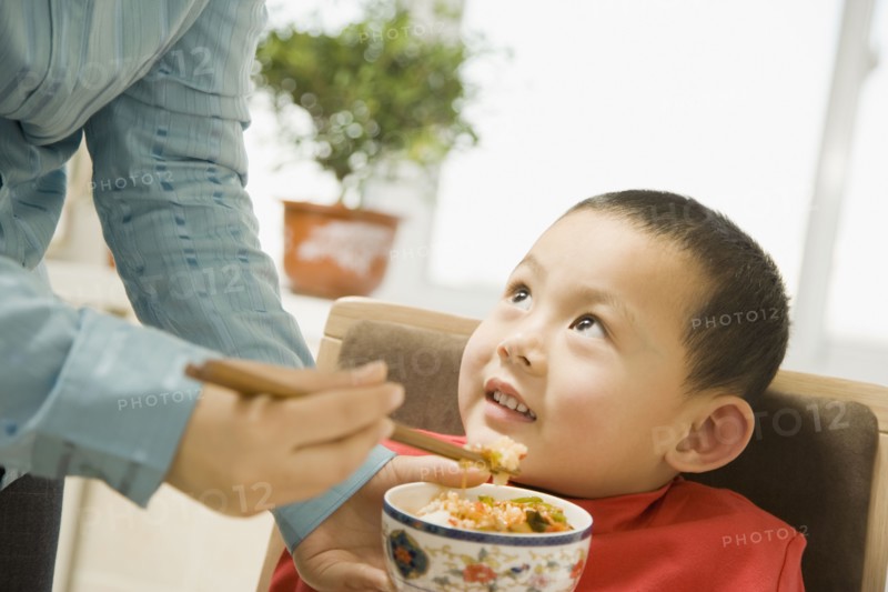 Chinese grandmother feeding son