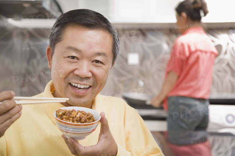 Chinese man eating with chopsticks