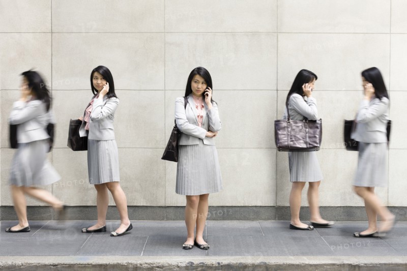 Multiple-exposure of Chinese businesswoman talking on cell phone