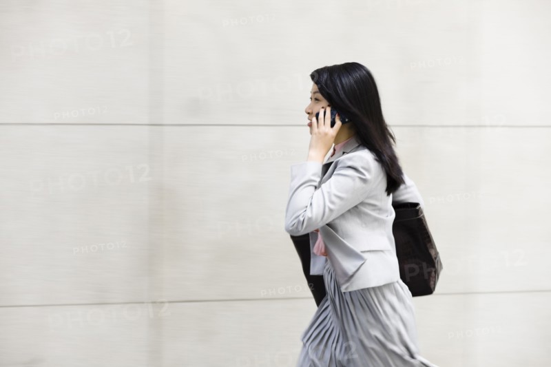 Chinese businesswoman walking and talking on cell phone