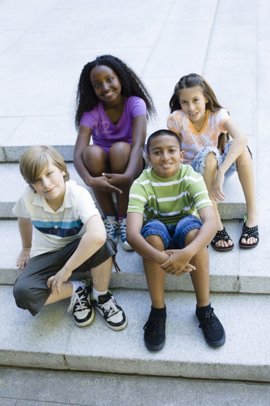 Smiling children sitting on steps together
