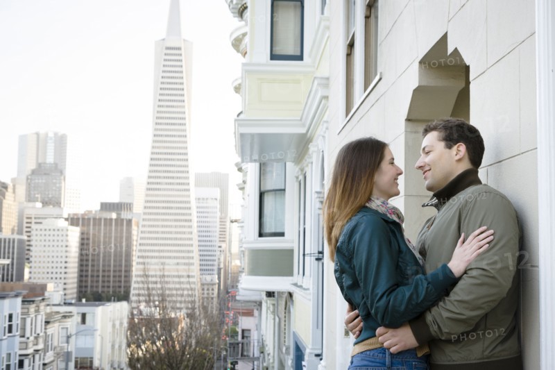 Caucasian couple hugging in city