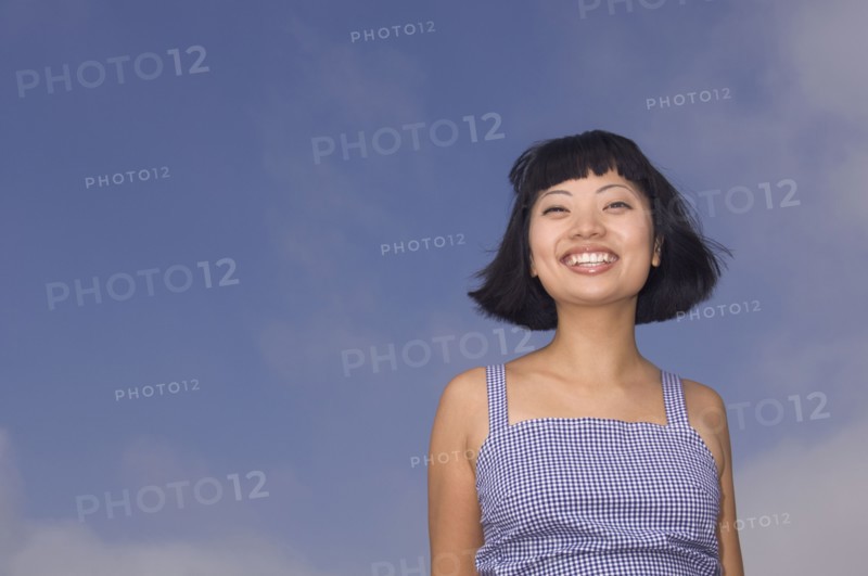 Portrait of Asian woman under blue sky