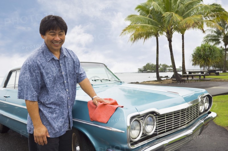 Asian man waxing car