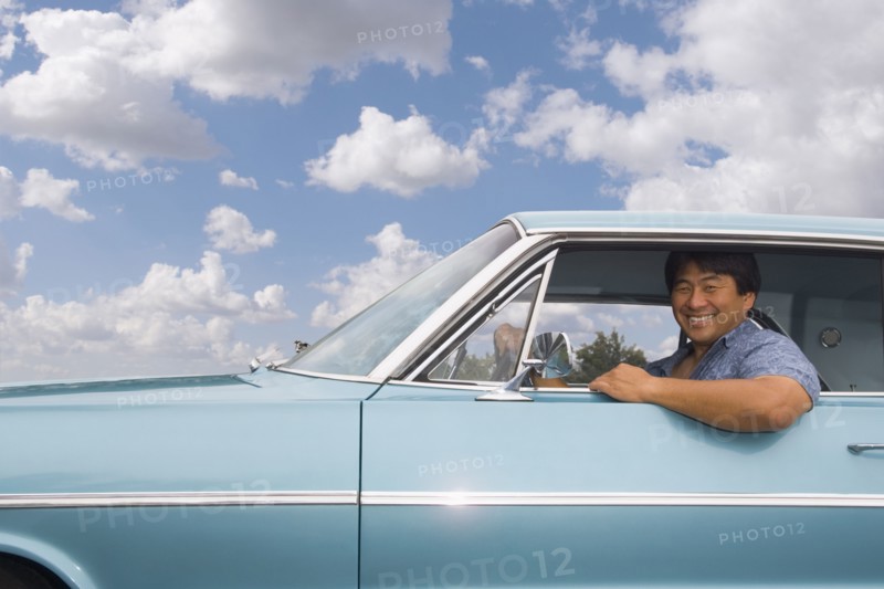 Asian man sitting in car