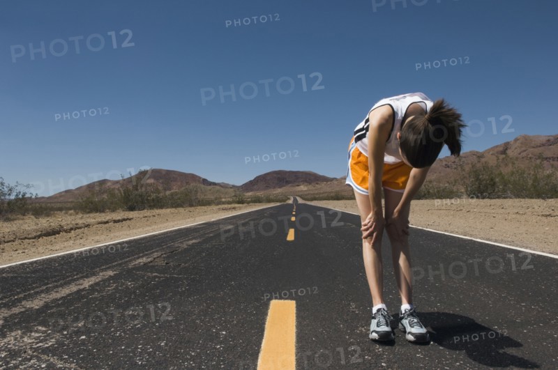 Mixed Race female runner stretching