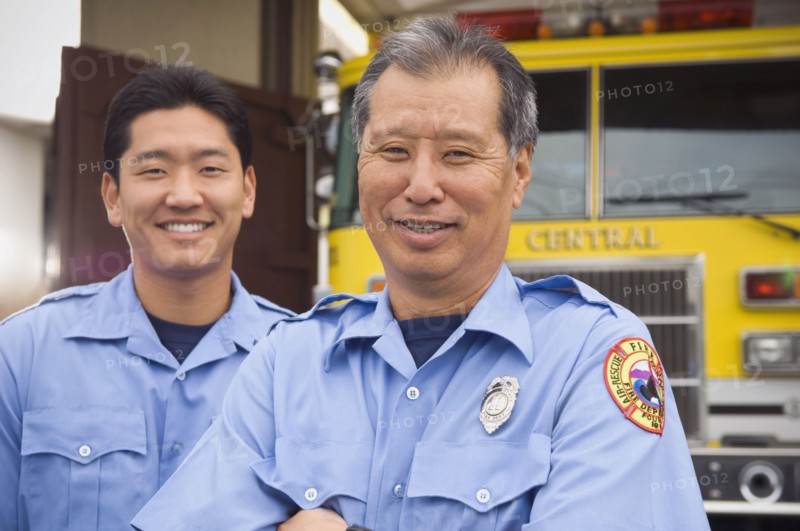 Asian male paramedics in front of ambulance