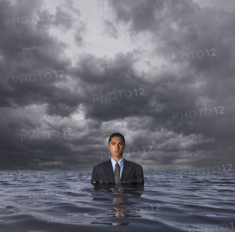 Hispanic businessman standing in water