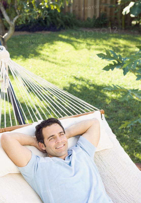 Mixed race man relaxing in hammock