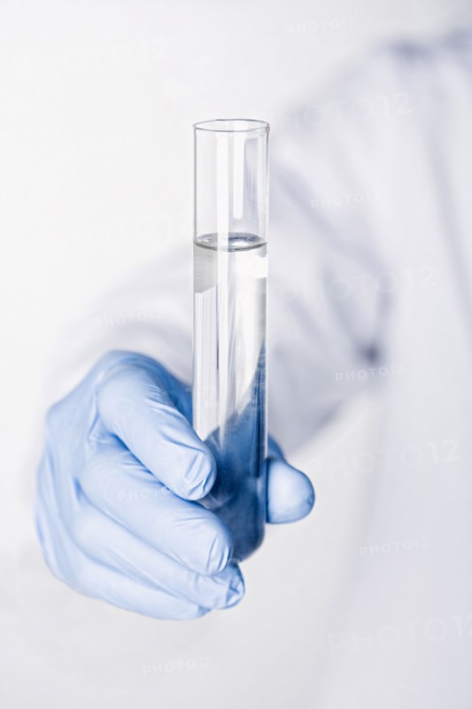 Hispanic scientist holding test tube full of water