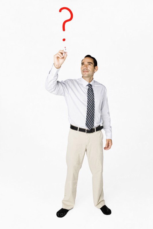 Hispanic businessman drawing question mark on clear board
