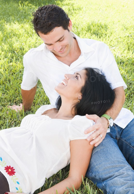 Pregnant woman laying in husband's lap