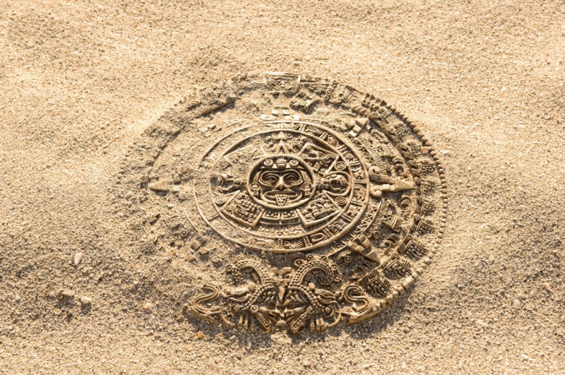 Aztec calendar stone carving on sand