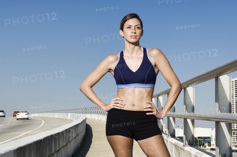 Hispanic woman in sportswear standing with hands on hips