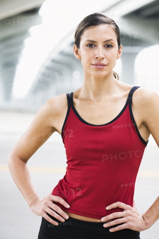 Hispanic woman in sportswear standing in urban area