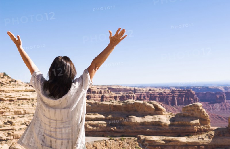 Hispanic woman cheering near canyon