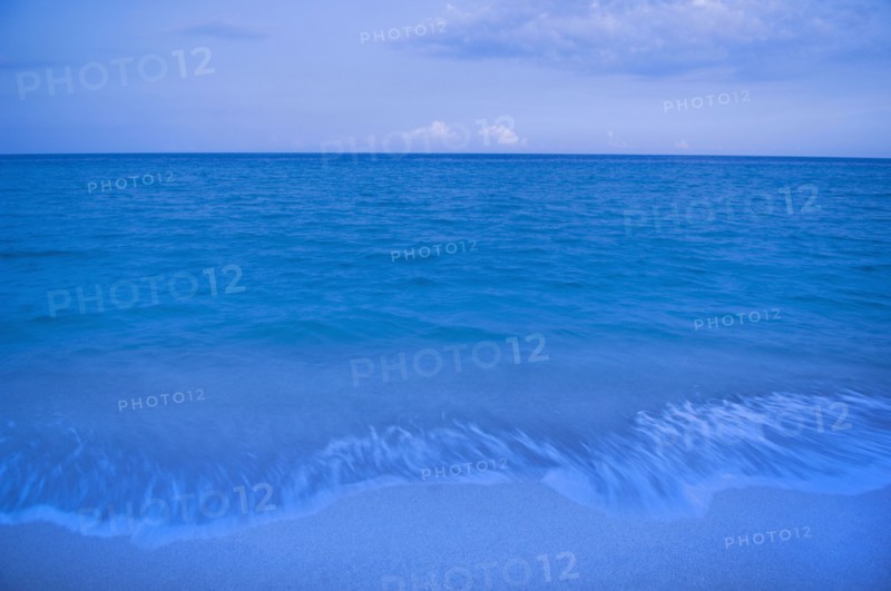 Waves on beach of tranquil blue ocean