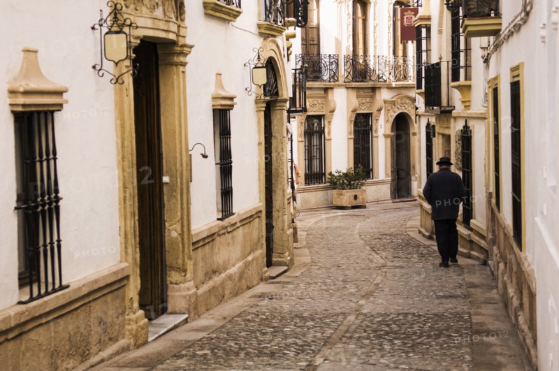 Man walking down cobblestone alley in quaint village