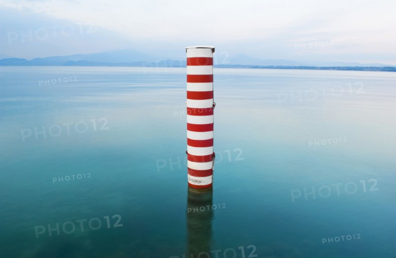 Red and white stripe pillar in tranquil lake