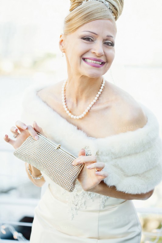 Smiling Hispanic bride holding purse