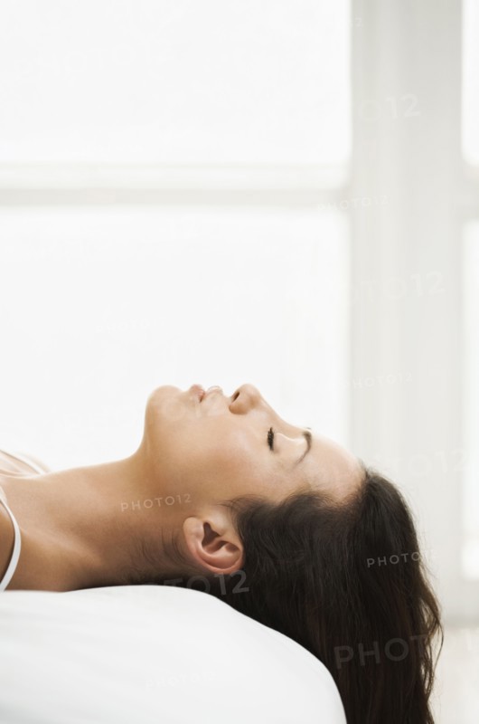 Hispanic woman laying on bed