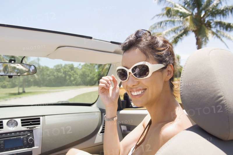 Hispanic woman riding in convertible