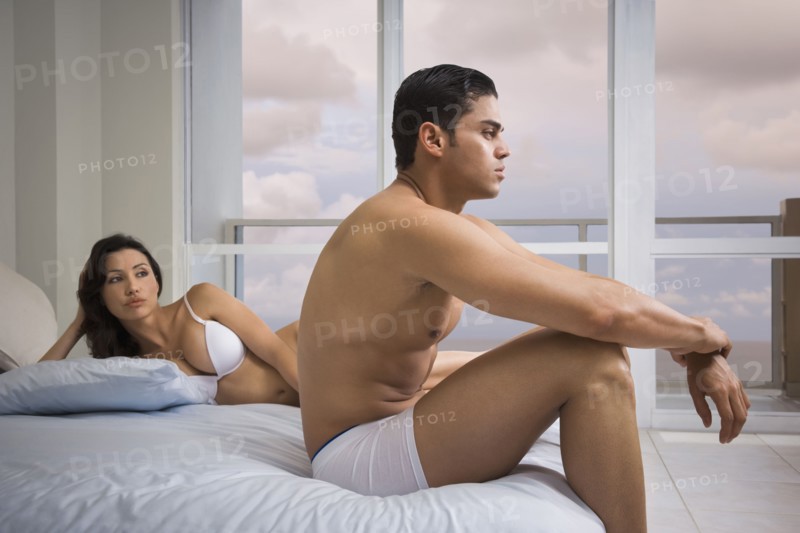 Hispanic couple arguing on bed