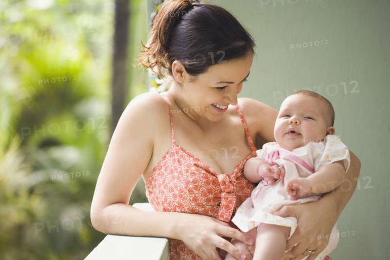 Mixed race mother smiling at baby