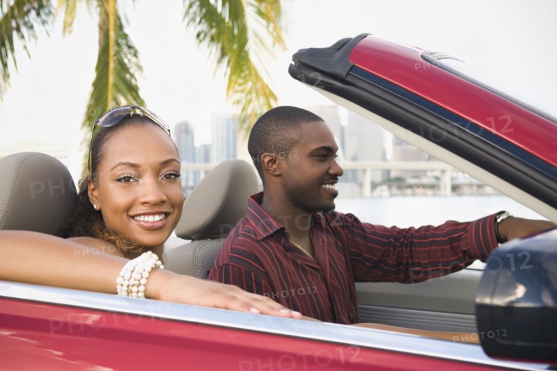 African American couple driving in convertible
