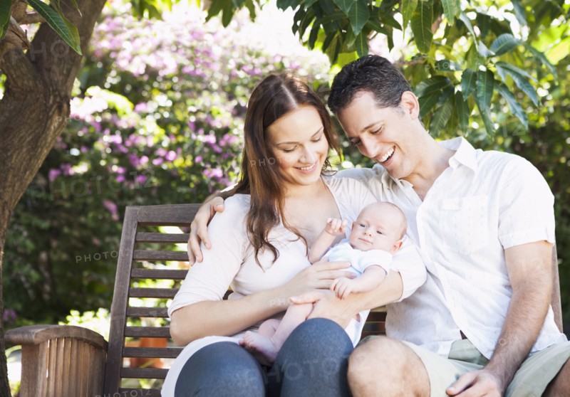 Caucasian couple holding baby outdoors