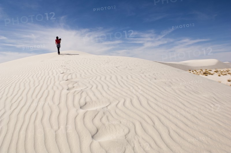 Man climbing sand dune in desert
