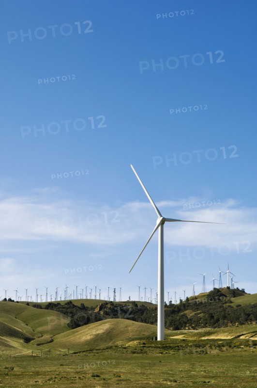 Wind turbines lining hilltop in rolling landscape