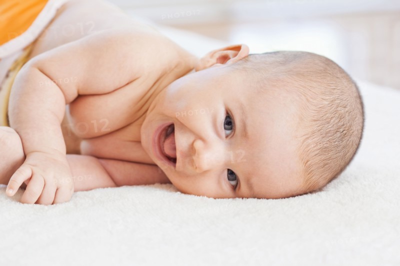 Mixed race baby laying on blanket